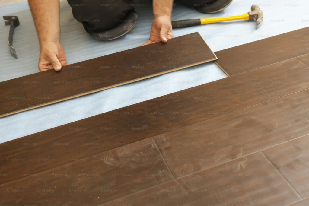 Waterproof SPC flooring with water droplets on a warm oak rigid-core floor surface
